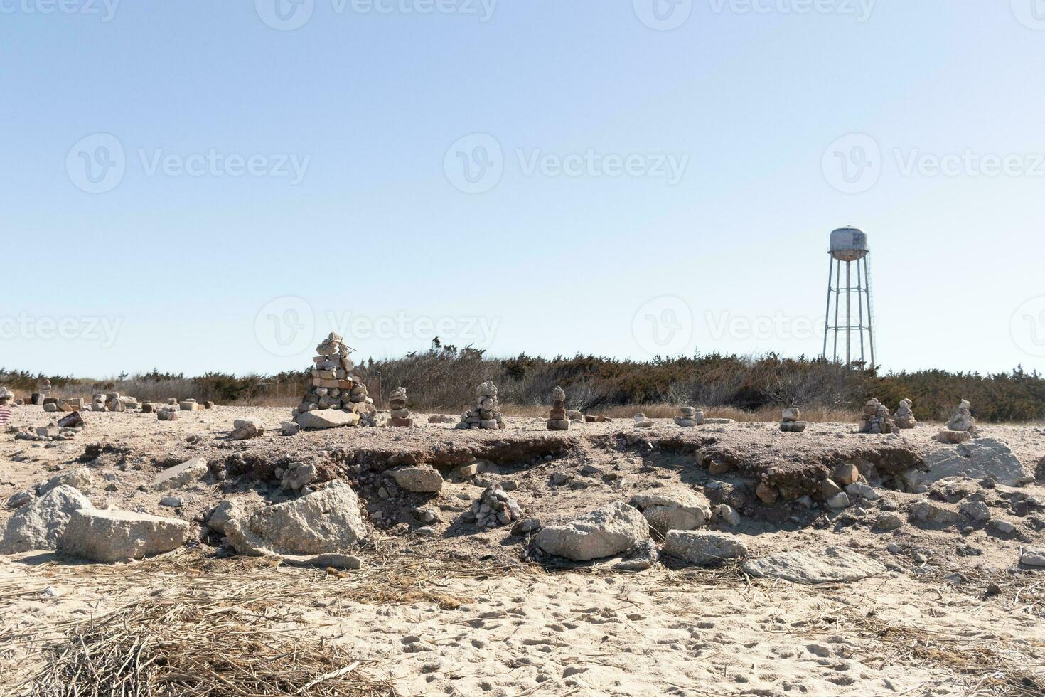This rocky beach was at Sunset Beach in Cape May New Jersey. This beach is iconic for all the pebbles and rocks that are on it. The sand dunes in the back really add to this image. photo