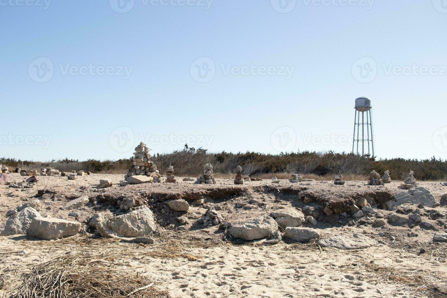 This rocky beach was at Sunset Beach in Cape May New Jersey. This beach is iconic for all the pebbles and rocks that are on it. The sand dunes in the back really add to this image. photo