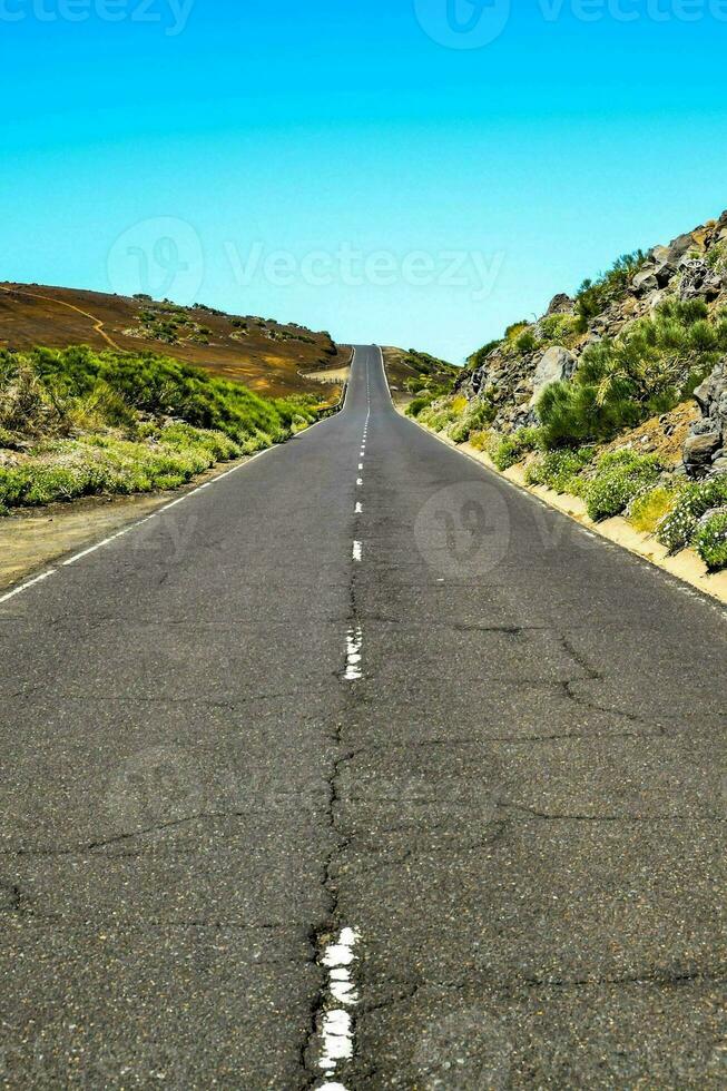 an empty road in the middle of a desert photo