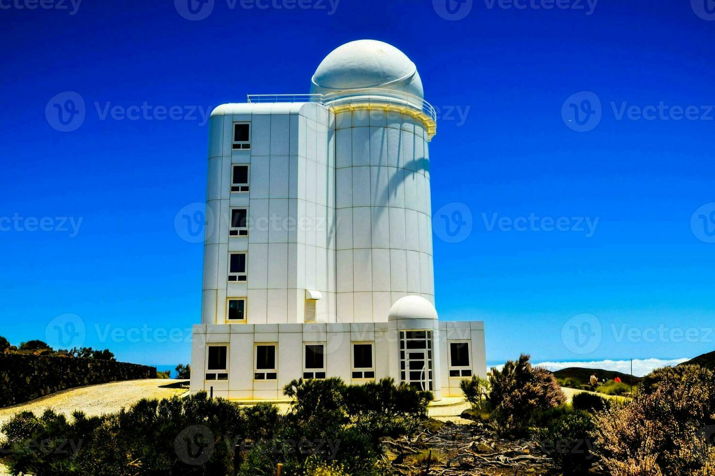 a white dome on top of a hill with a blue sky photo