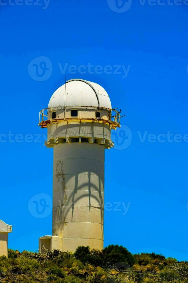 a white dome on top of a hill with a blue sky photo