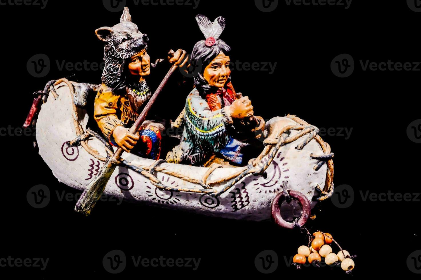 a figurine of two native american men in a canoe photo