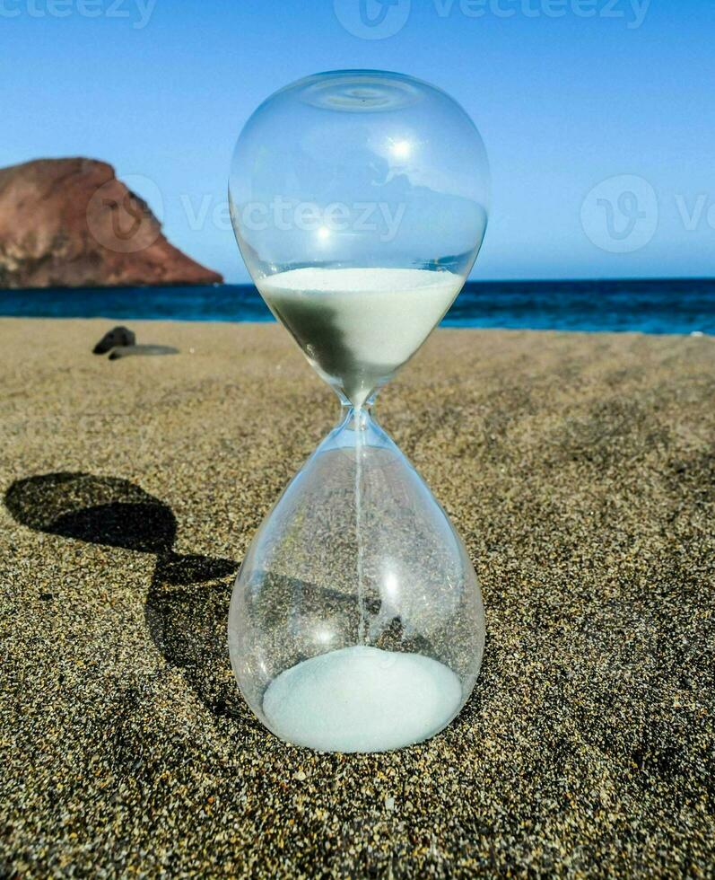 an hourglass on the beach with sand and water photo