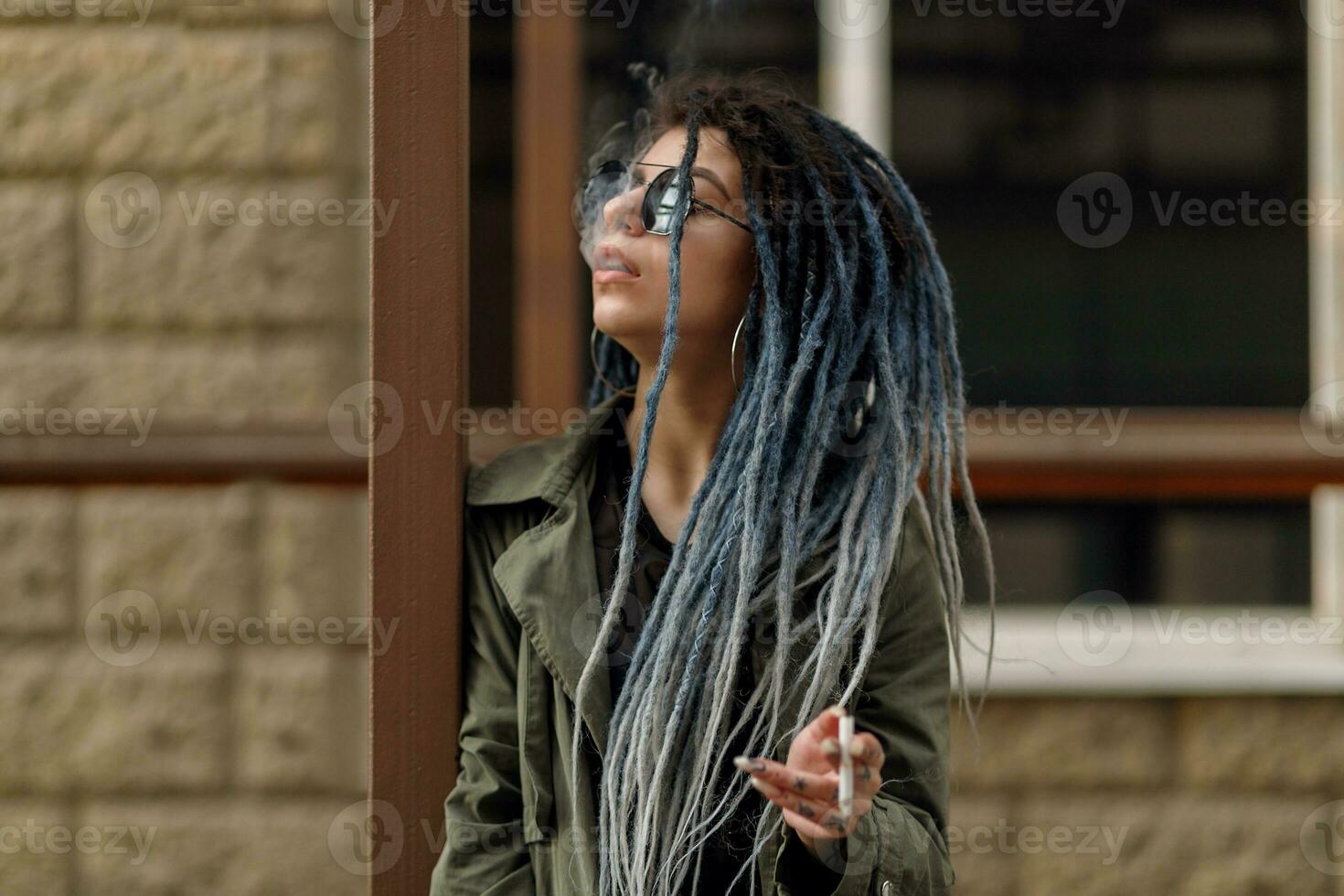 cheerful caucasian girl looking at the camera and smiling model with dreadlocks photo