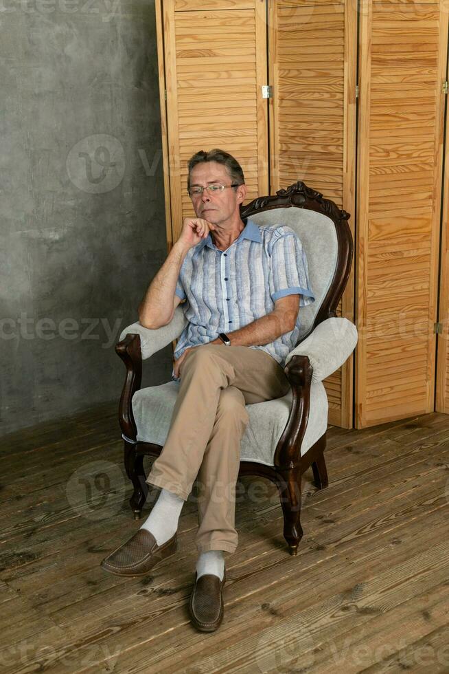 An old intelligent man having a rest on a armchair photo