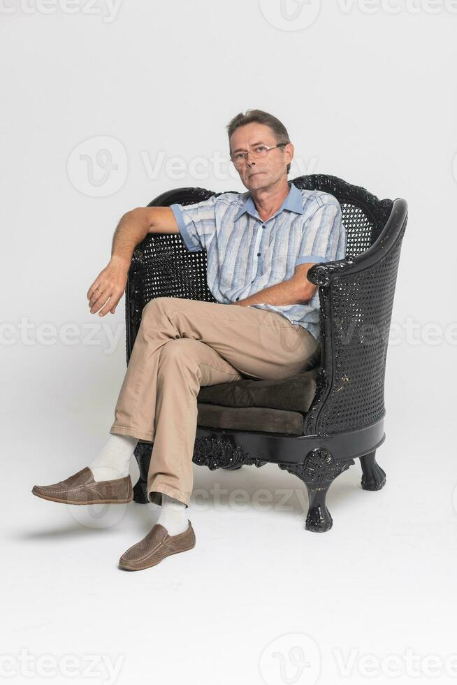 Senior sitting in an armchair and pensive, dreamy photo