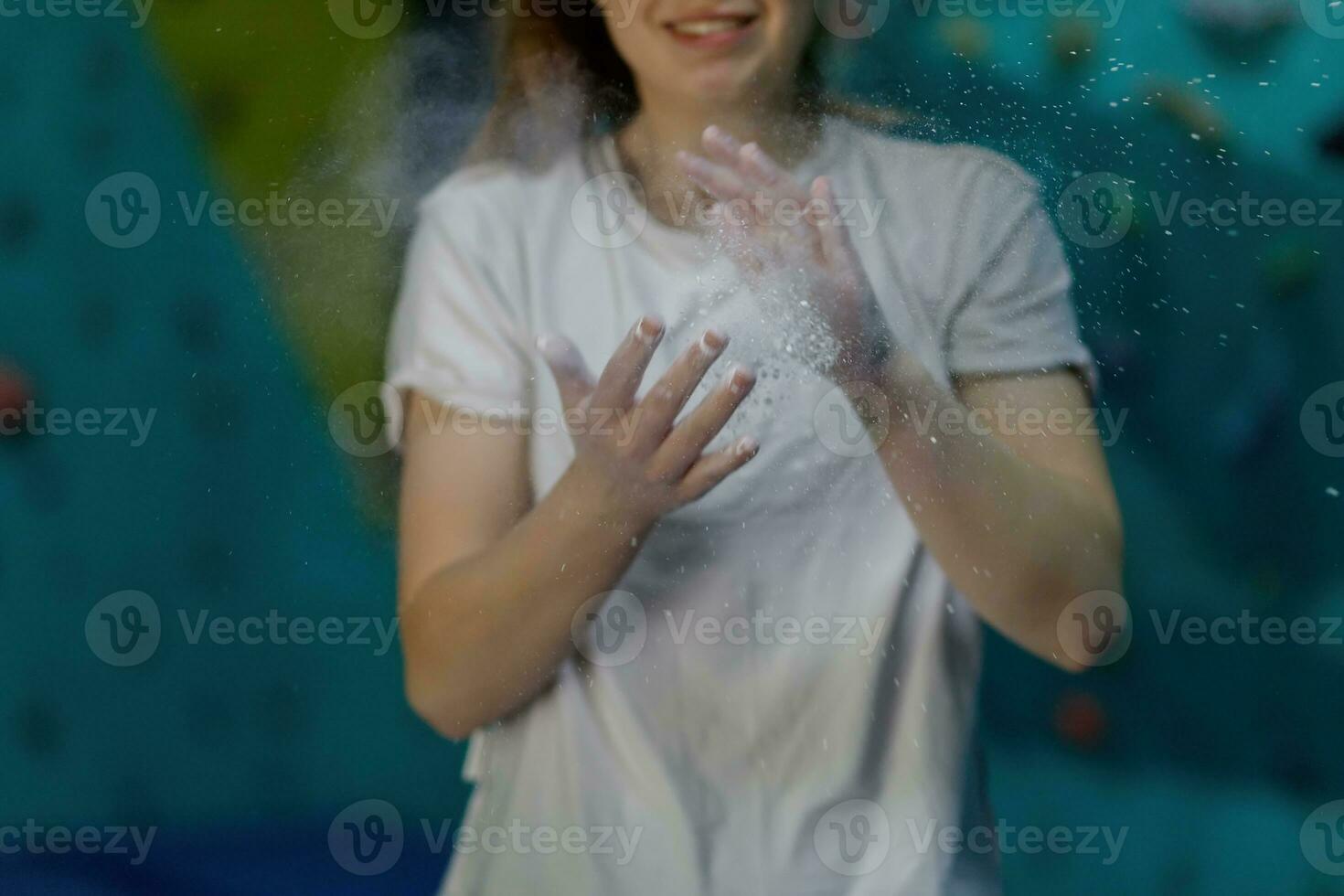 Young woman climbing up on practice wall in gym photo