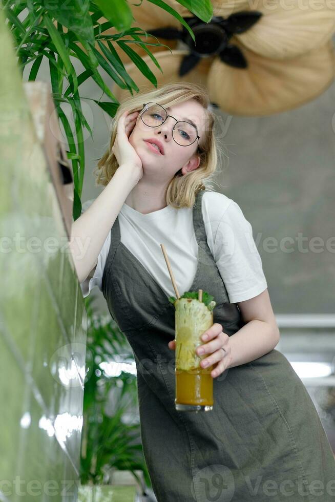 Close up young cheerful woman in dress happily looking in camera photo