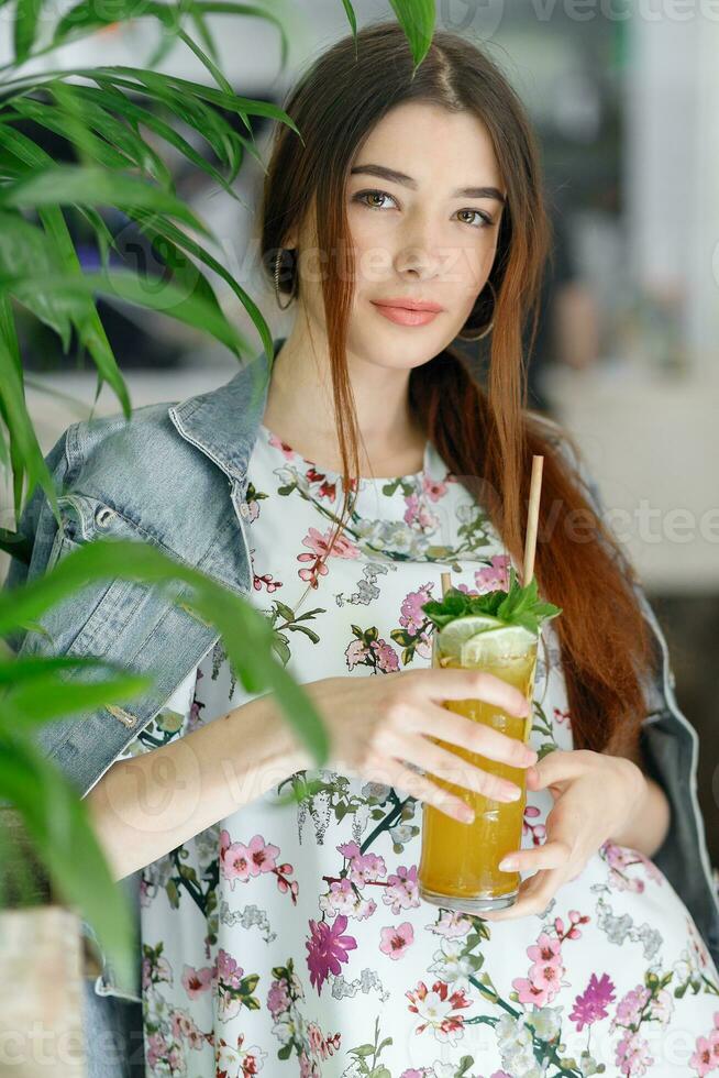 Close up young cheerful woman in dress happily looking in camera photo