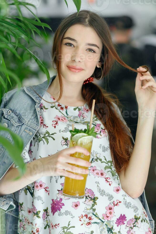 Close up young cheerful woman in dress happily looking in camera photo