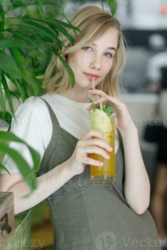 Close up young cheerful woman in dress happily looking in camera photo