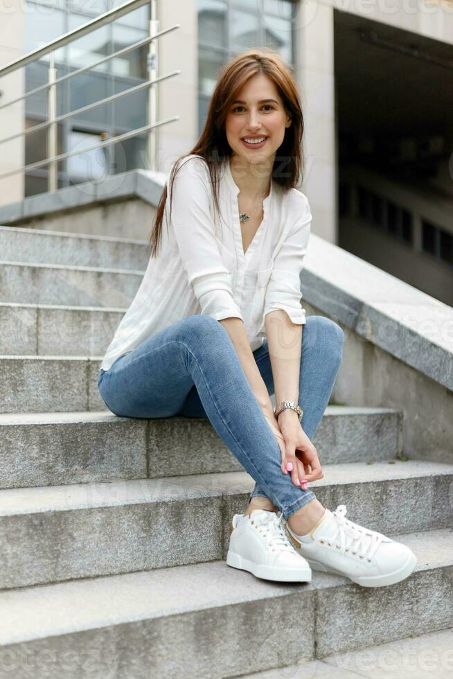 Attractive young woman in the city. Business lady standing near business center photo