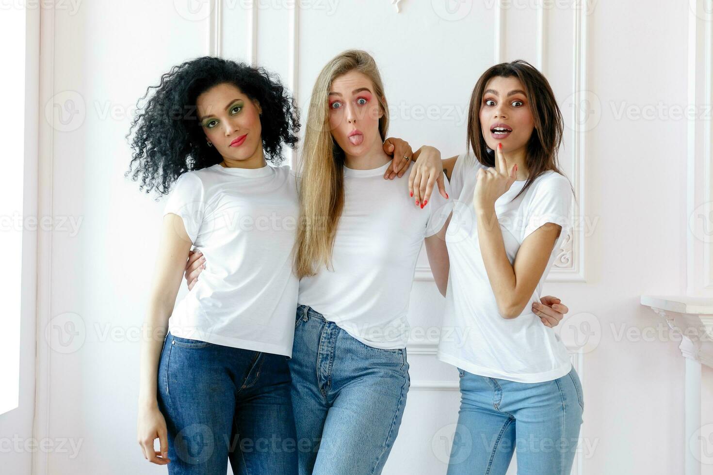 Portrait of three seductive multiethnic women standing together photo