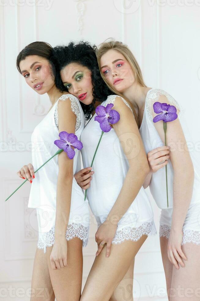 Portrait of three gorgeous multiracial young women with different types of skin photo