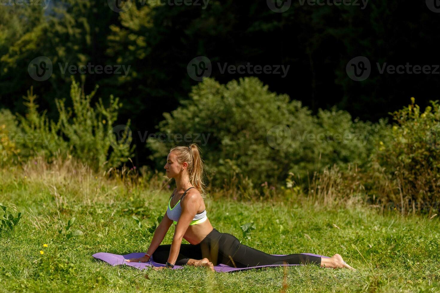 Fitness woman sitting in a yoga pose in a park. photo