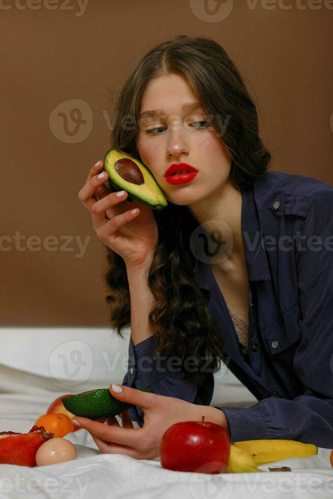 Young woman in group of fruit. Healthcare. photo