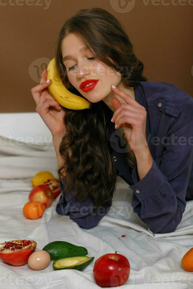 Young woman in group of fruit. Healthcare. photo