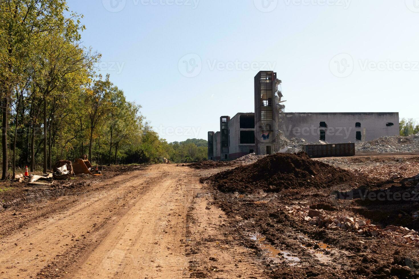 I love the look of this abandoned village. The dirt road leading to the factory. The brick building is without windows. Most glass has been broken and has some have graffiti. photo