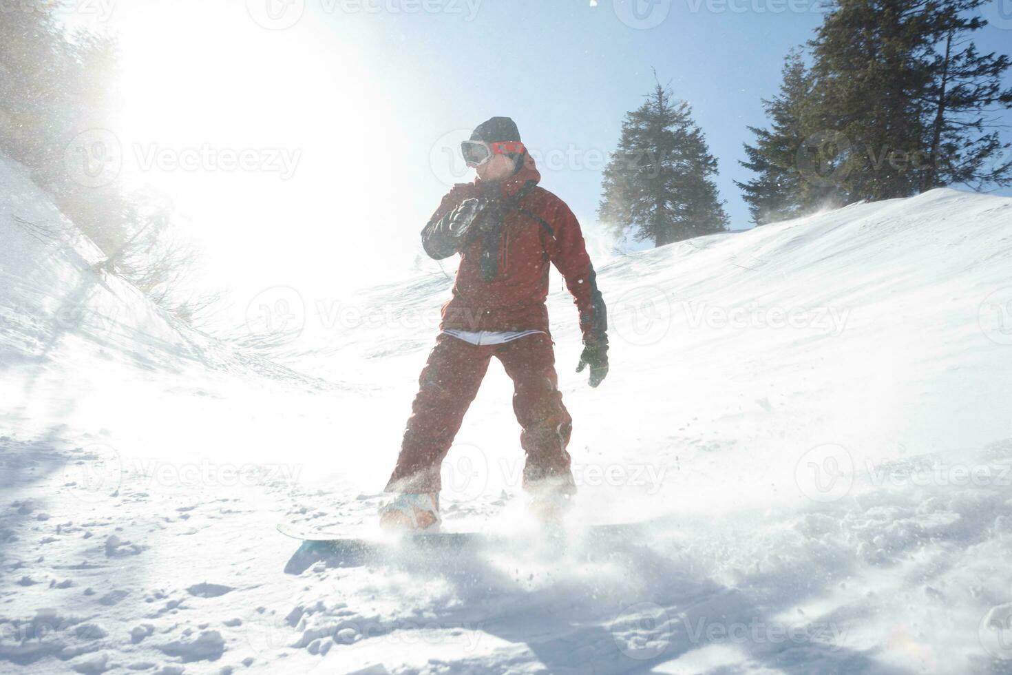 Active snowboarder jumping in mountains on a sunny day photo