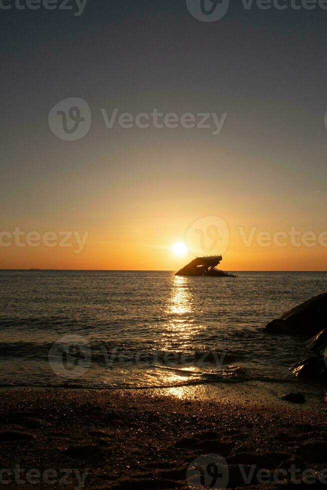 puesta de sol playa en capa mayo nuevo jersey dónde usted lata obtener un genial ver de el Dom yendo abajo a través de el Oceano y el bahía. el reflexión de el Dom en el agua con el hundido Embarcacion mira entonces hermosa. foto