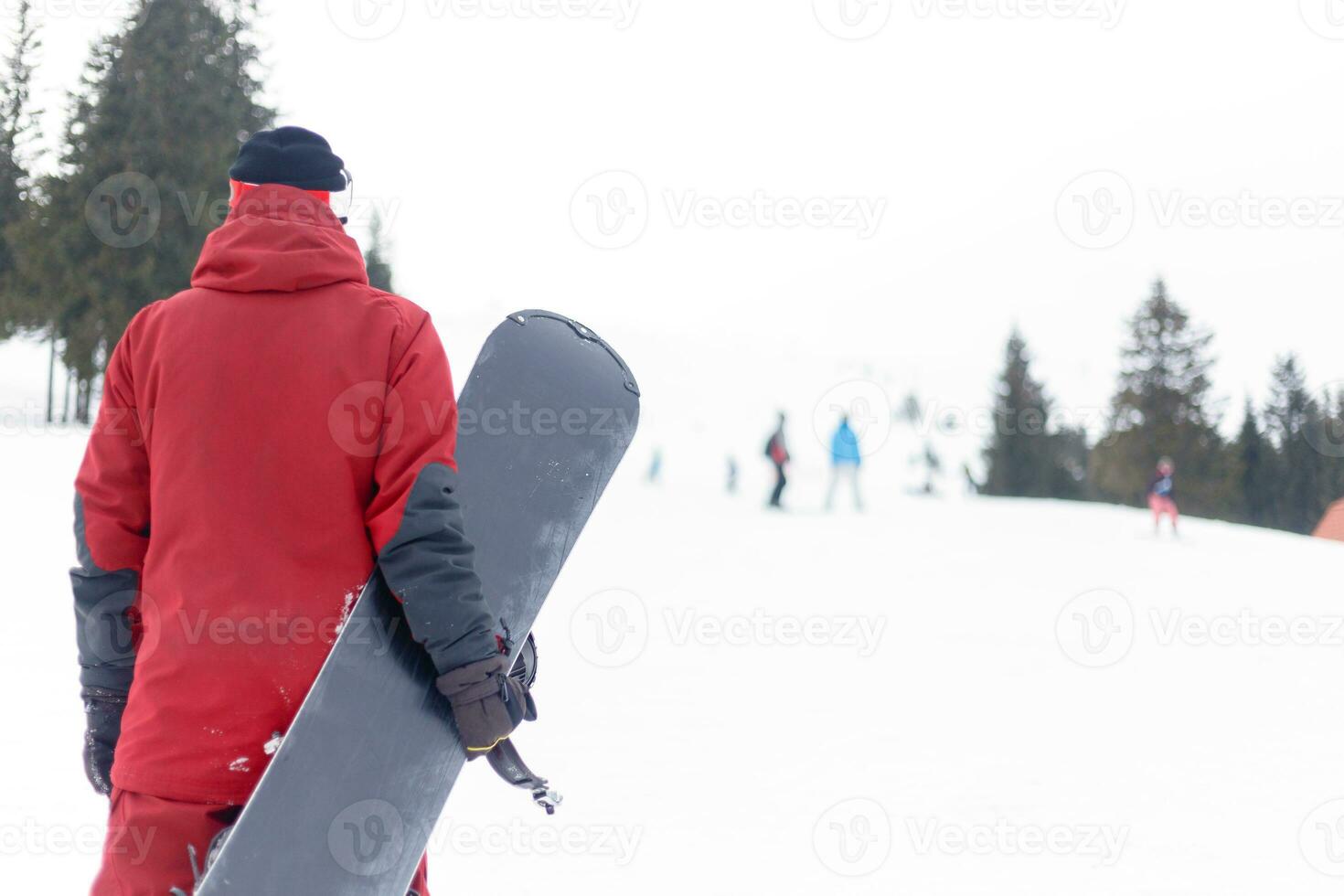 Snowboarder in helmet standing at the very top of a mountain photo