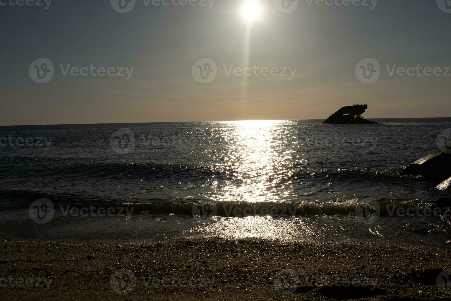 Sunset beach in Cape May New Jersey where you can get a great view of the sun going down across the ocean and the bay. The reflection of the sun on the water with the sunken ship looks so beautiful. photo