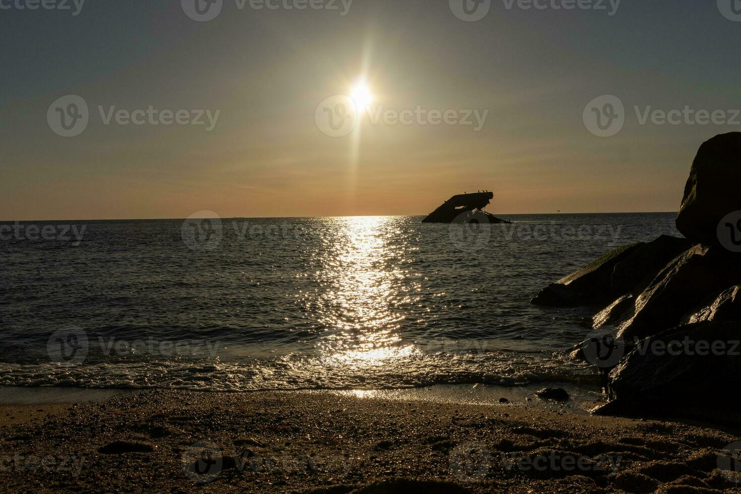 puesta de sol playa en capa mayo nuevo jersey dónde usted lata obtener un genial ver de el Dom yendo abajo a través de el Oceano y el bahía. el reflexión de el Dom en el agua con el hundido Embarcacion mira entonces hermosa. foto