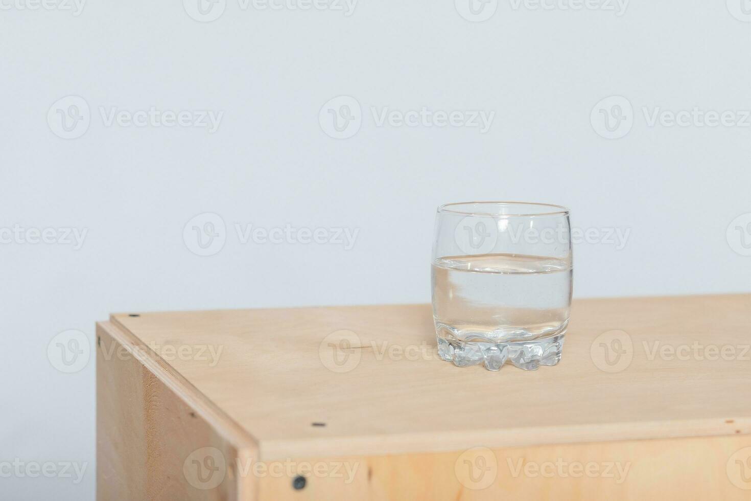 Tall glass full of lightly carbonated drinking water standing photo