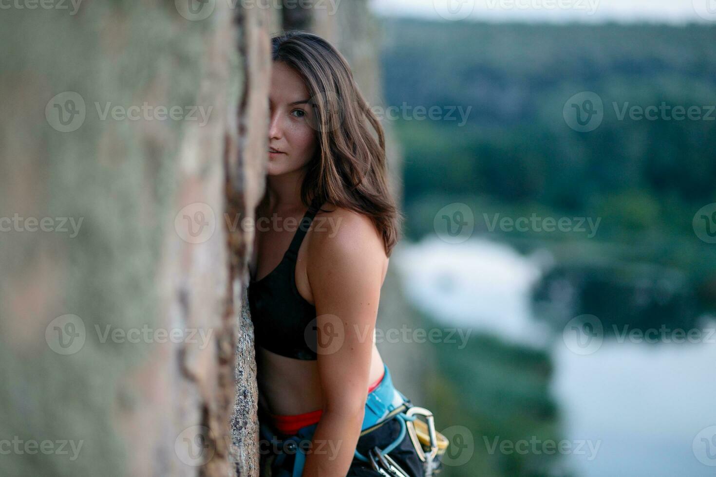 A girl climbs a rock. Woman engaged in extreme sport. photo