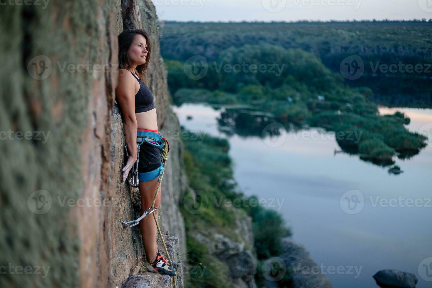 A girl climbs a rock. Woman engaged in extreme sport. photo