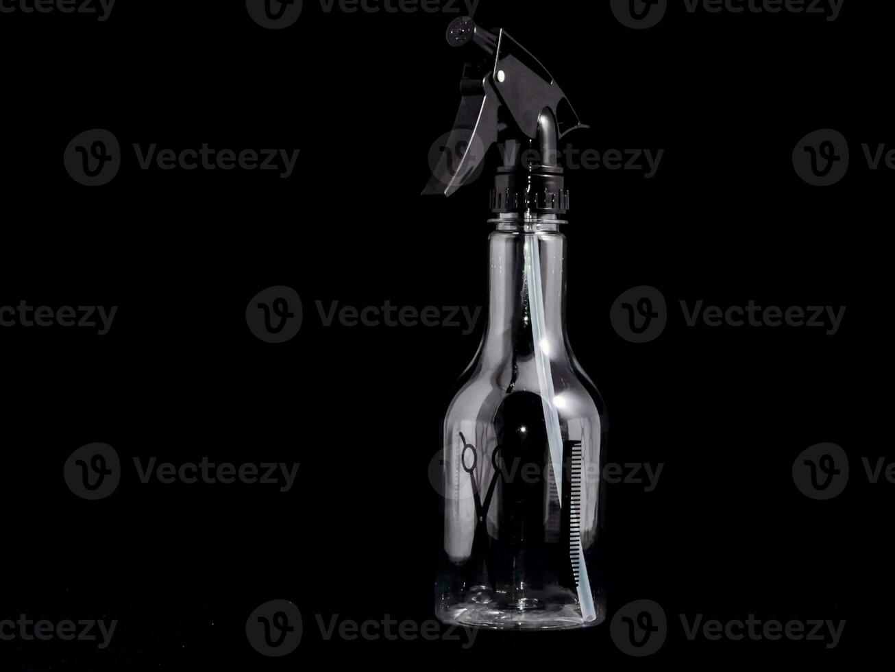 a spray bottle with a black handle on a black background photo