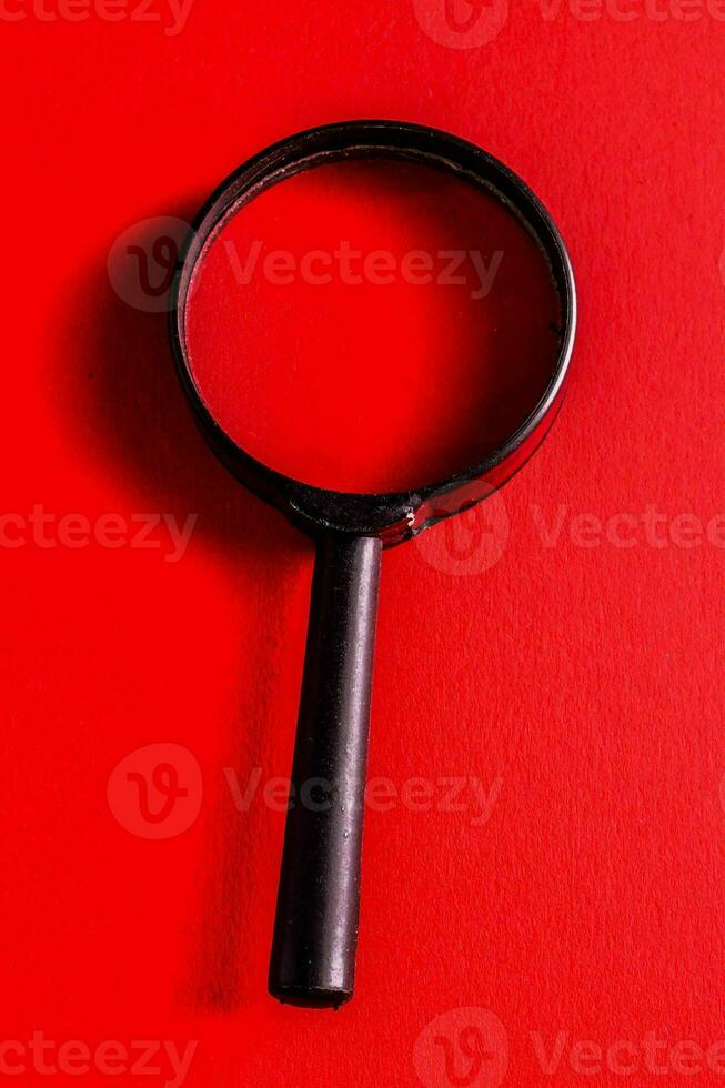 a magnifying glass on a red background photo