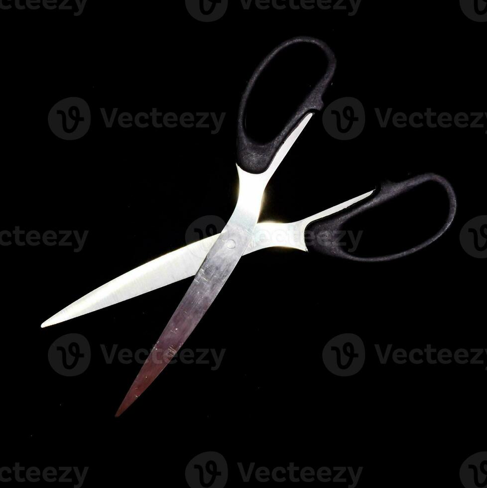 a pair of scissors on a black background photo