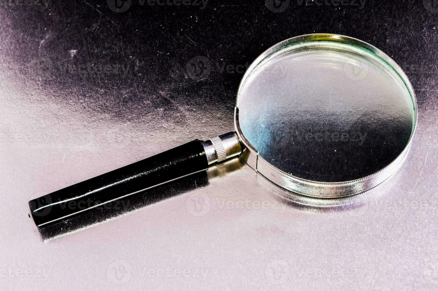 a magnifying glass on a shiny surface photo