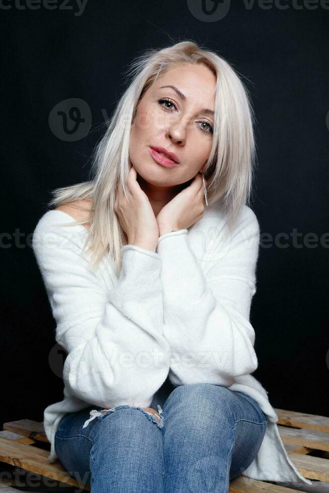 retrato de un hermosa joven atractivo mujer en un blanco suéter foto