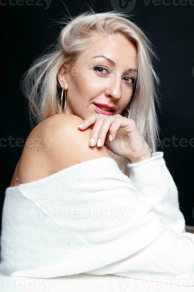 retrato de un hermosa joven atractivo mujer en un blanco suéter foto