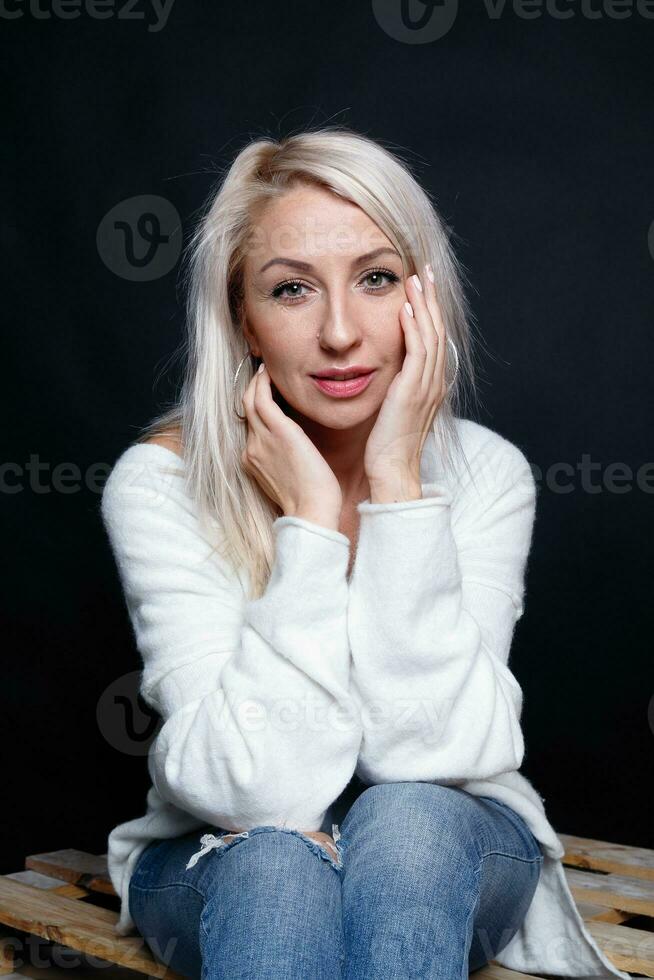 Portrait of a beautiful young attractive woman in a white sweater photo