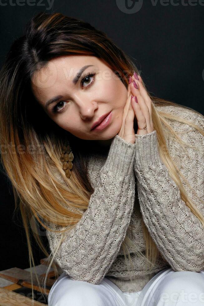 Portrait of beautiful red haired female in grey melange sweater photo