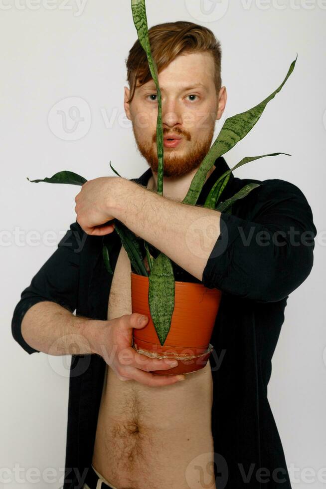 A young smiling man holds in his hands a small flower photo