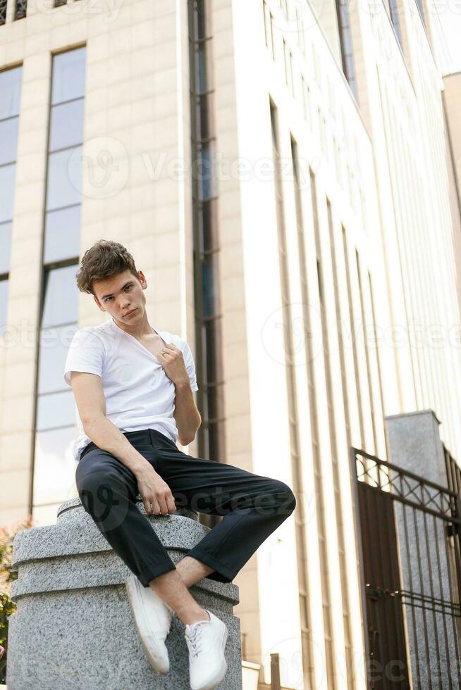 hermoso joven hipster elegante hombre en blanco camisa, negro pantalones foto