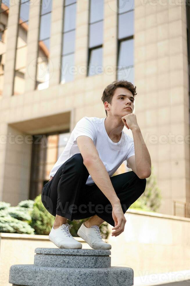 Handsome young hipster stylish man in white shirt, black pants photo
