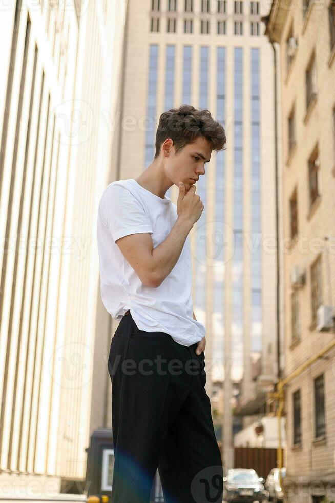 Handsome young hipster stylish man in white shirt, black pants photo