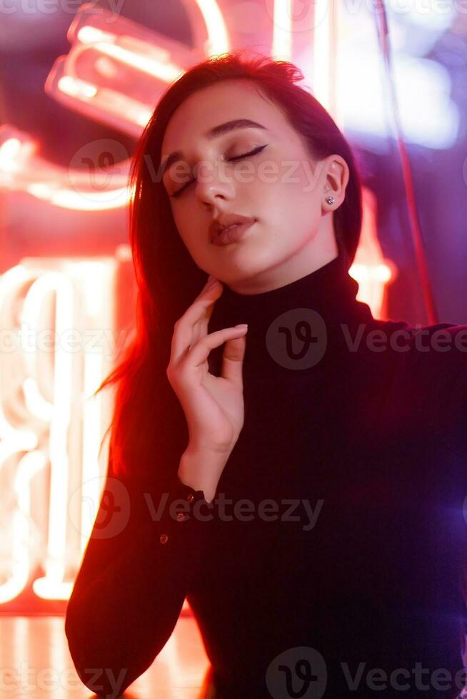 Portrait of a girl on the background of a neon sign of a shop window photo