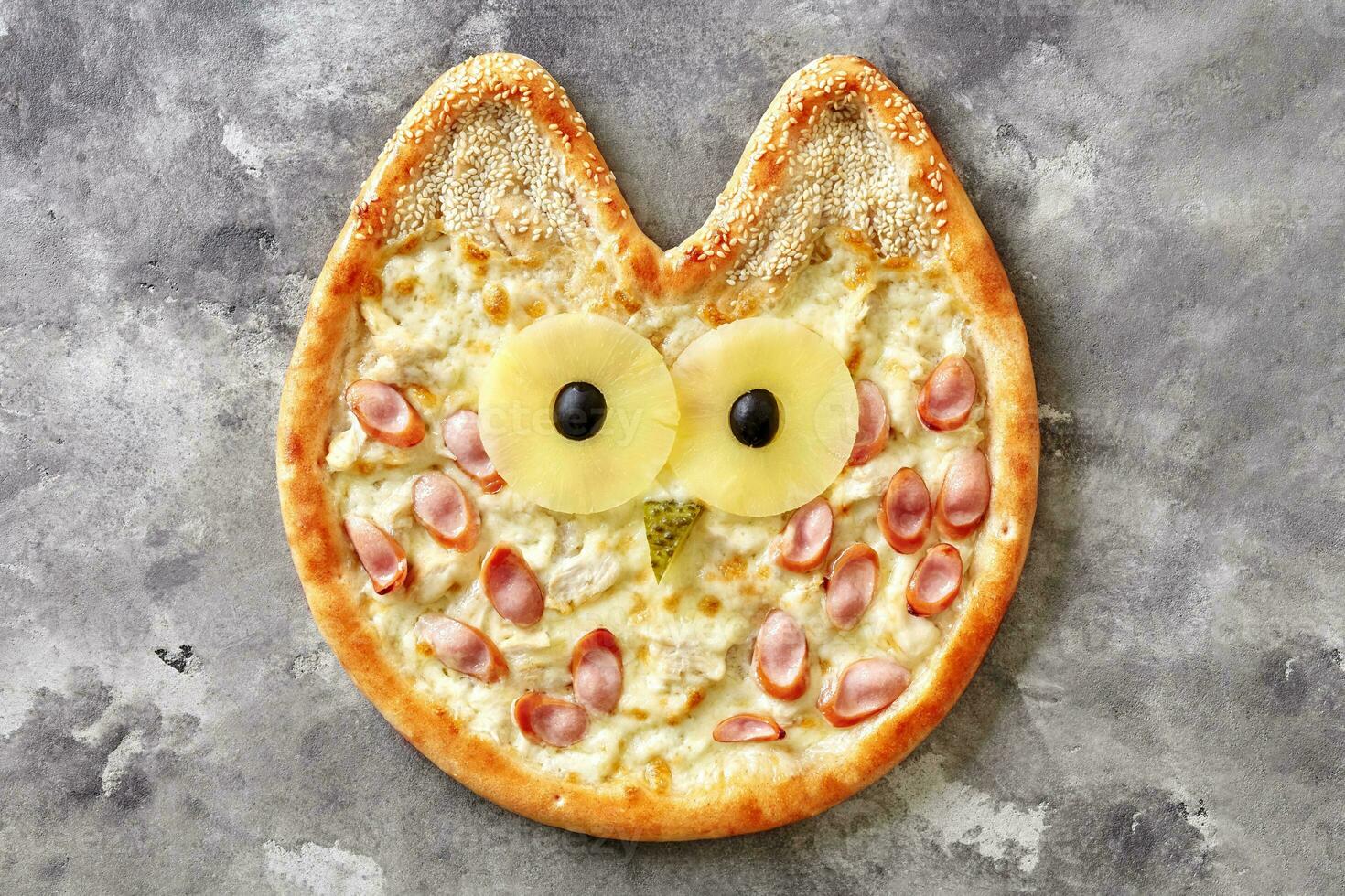 Owl-shaped pizza for kids with cream cheese sauce, chicken, Vienna sausage, pineapple, olives, pickled cucumber and sesame photo