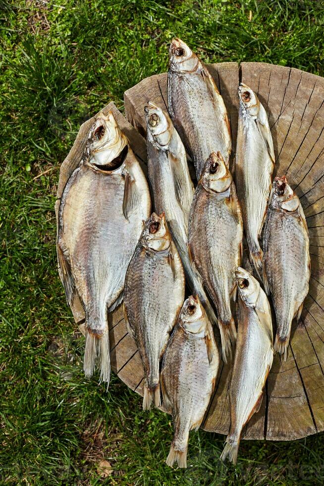 montón de salado secado al sol pescado en de madera tocón al aire libre foto