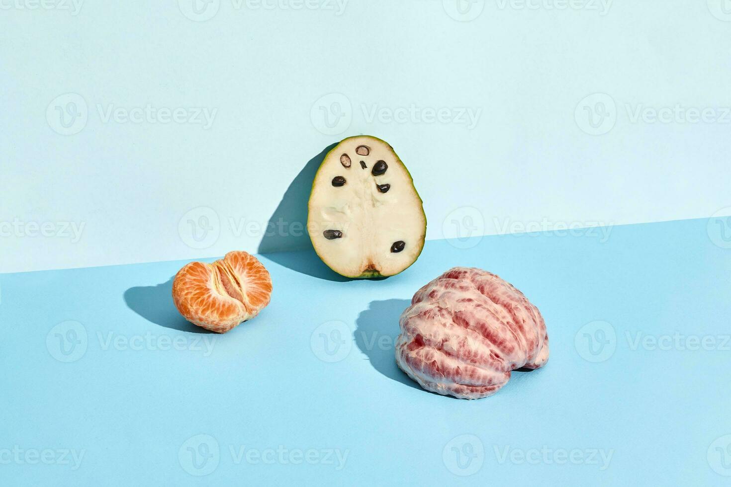 Half of sugar-apple, fruit of Annona squamosa cherimoya and mandarin and grapefruit photo