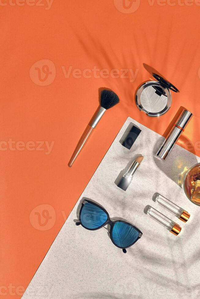 Woman's accessories lying flat on textured paper background. Orange and white colors with copy space around products. photo