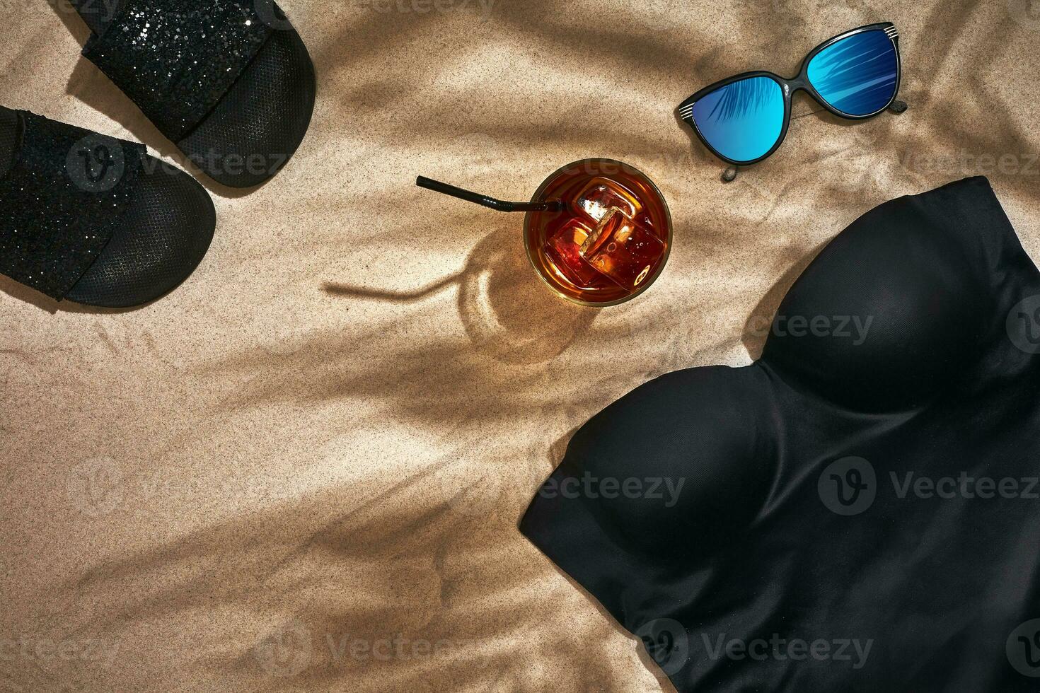 Women's beach accessories or summer outfit on sand background. Top view with copy space photo