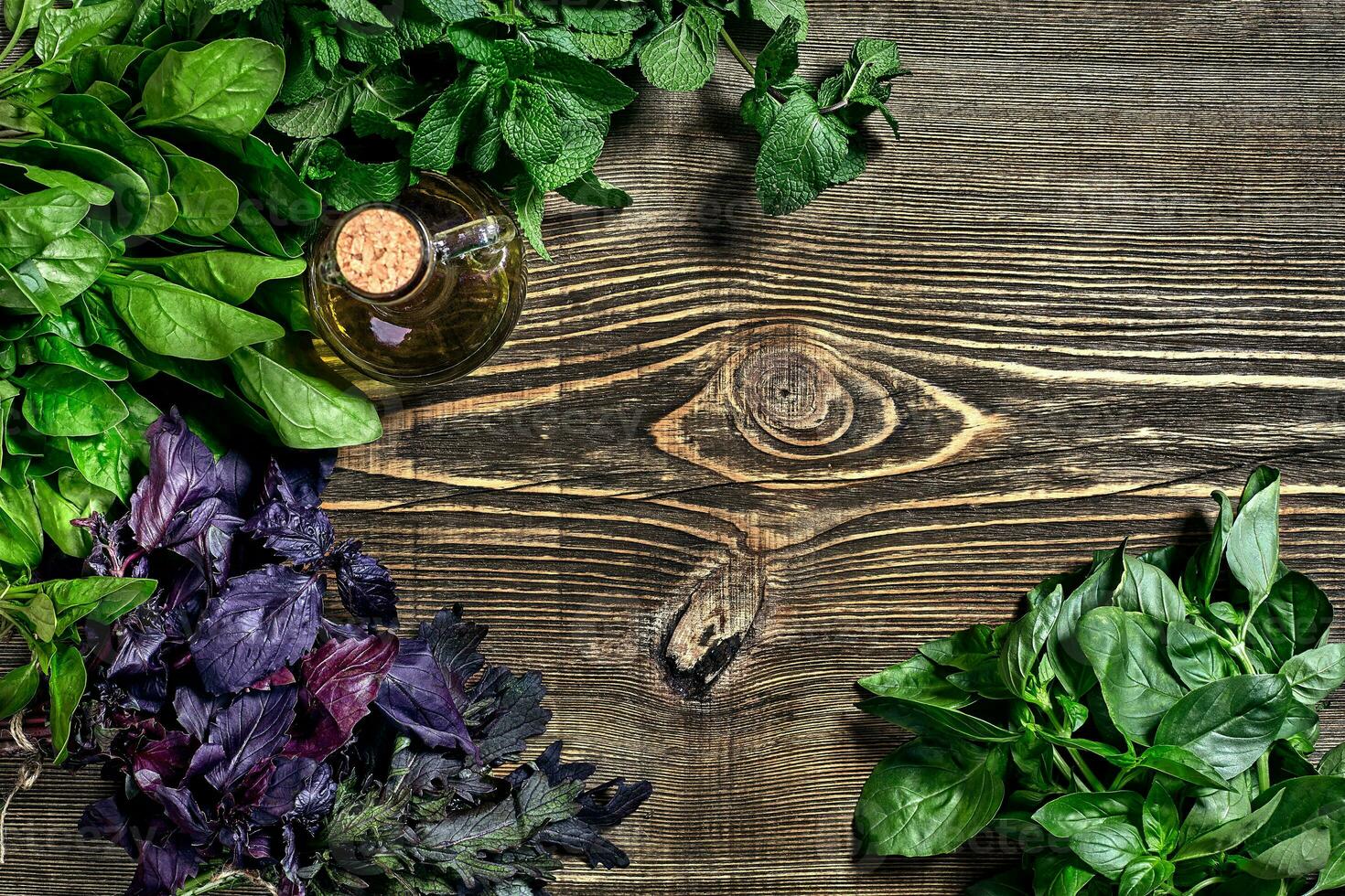 Variety of fresh organic herbs on wooden background. Freshly harvested herbs including basil, arugula. Top view. Copy space. photo