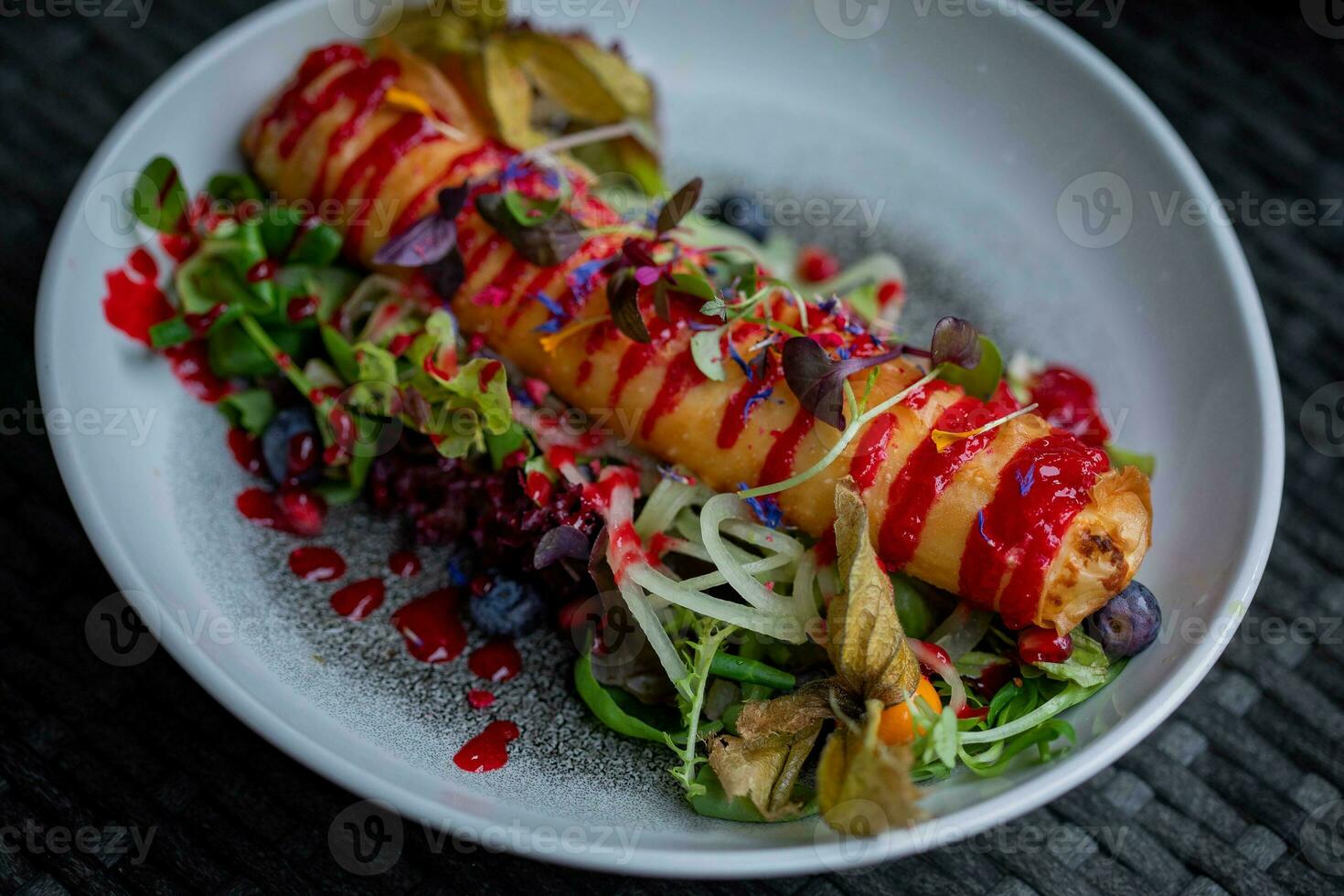 Fruit salad with berry sauce on a dark wooden background. photo